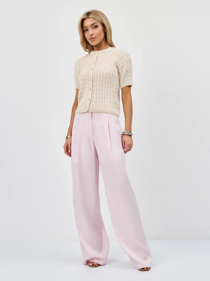 Lumiere Cardigan by Lauven, a soft lightweight knitwear with short sleeves and a cropped silhouette, styled with pink trousers.