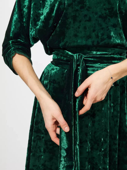 Close-up of Lauven Emerelle Maxi Dress in emerald green velvet featuring a tied waist and elegant texture.