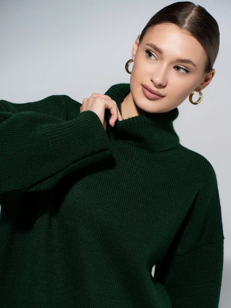 Model wearing the luxurious Lyra Sweater by Lauven in rich green knit with turtleneck design.