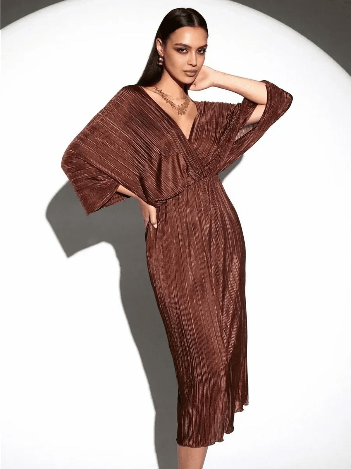 Model wearing the Vega Midi Dress by Lauven, showcasing its chocolate pleated fabric and elegant silhouette.