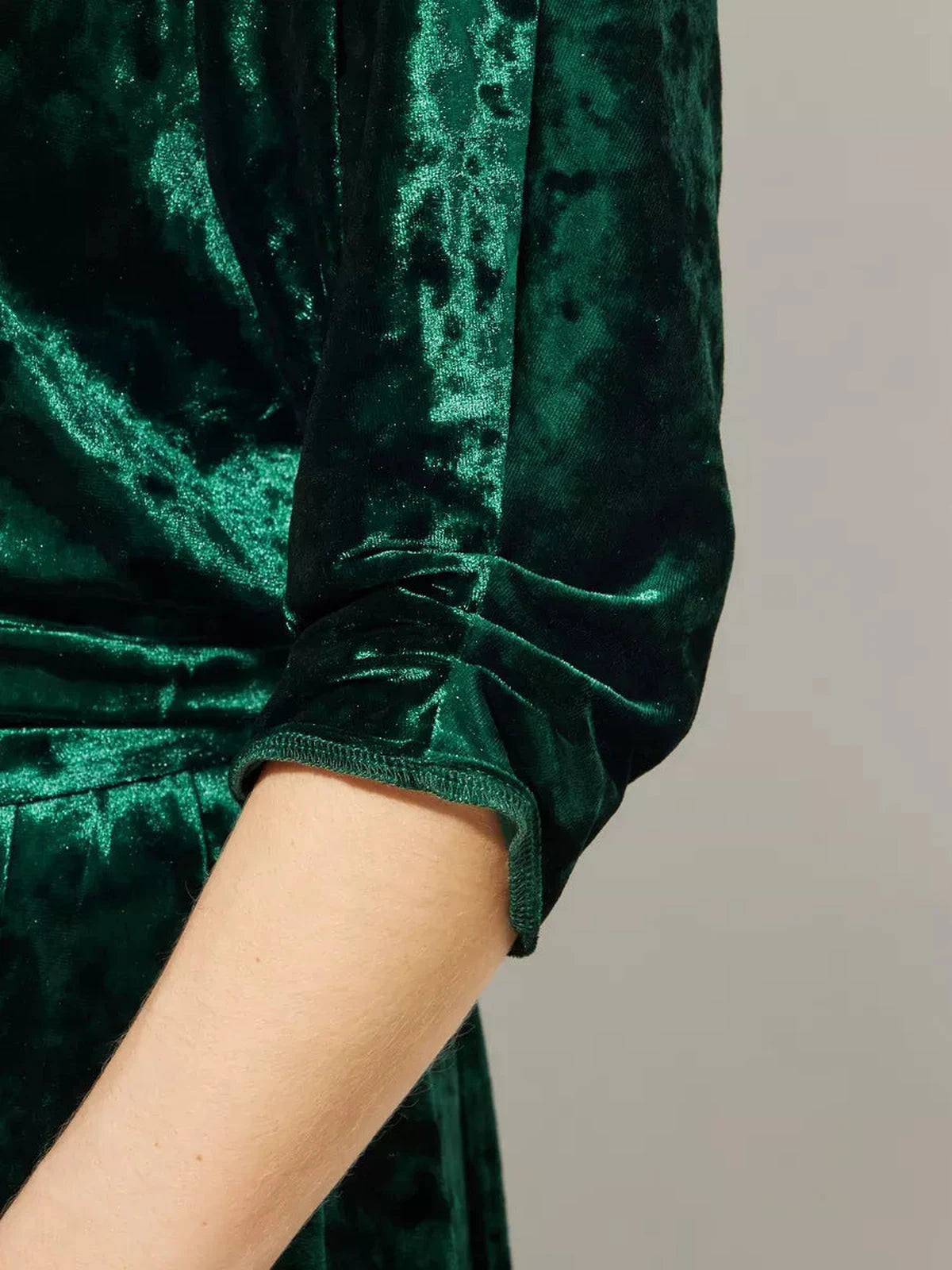 Close-up of the soft velvet fabric on the sleeve of the Emerelle Maxi Dress by Lauven in emerald green.