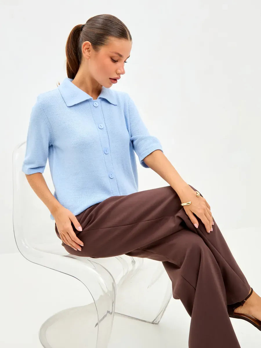 Lauven Alba Cardigan in lightweight blue wool blend, featuring a button closure, worn with brown trousers.