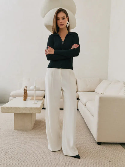 Nova Cardigan by Lauven - Black ribbed knit with two-way zipper, styled with chic white trousers.