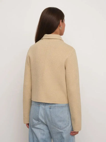 Back view of a woman wearing the Alba Jacket by Lauven, a cropped light beige women’s jacket.