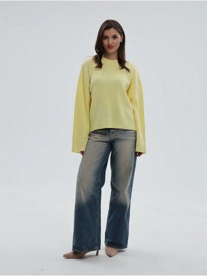Model wearing the Solara Sweater by Lauven, a light yellow oversized knit, styled with denim jeans.