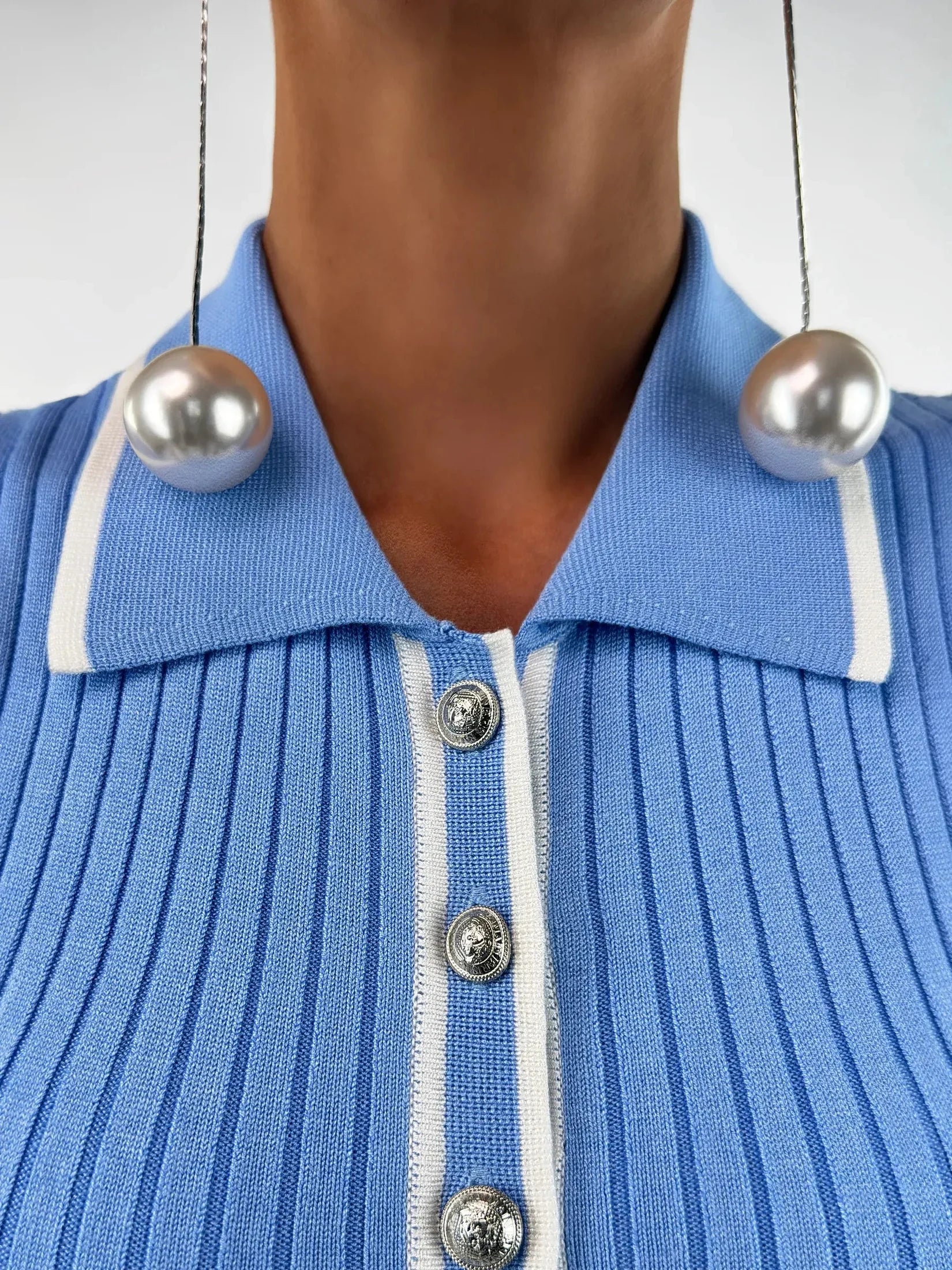 Close-up of the Celeste Midi Dress by Lauven, featuring a ribbed knit texture and sky blue color with pearl earrings.