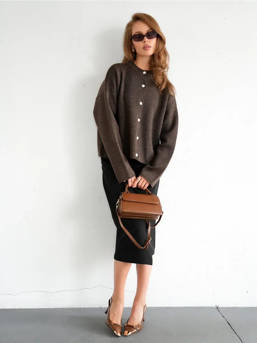 Model wearing Cocoa Cardigan in warm brown knit with button closure and stylish accessories.