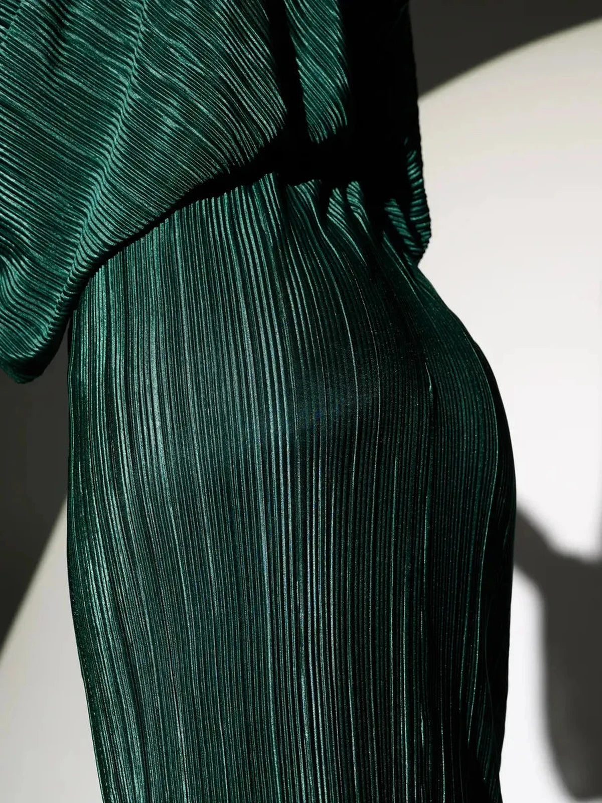 Astra Midi Dress by Lauven featuring elegant emerald pleated fabric, showcasing a flowing silhouette.