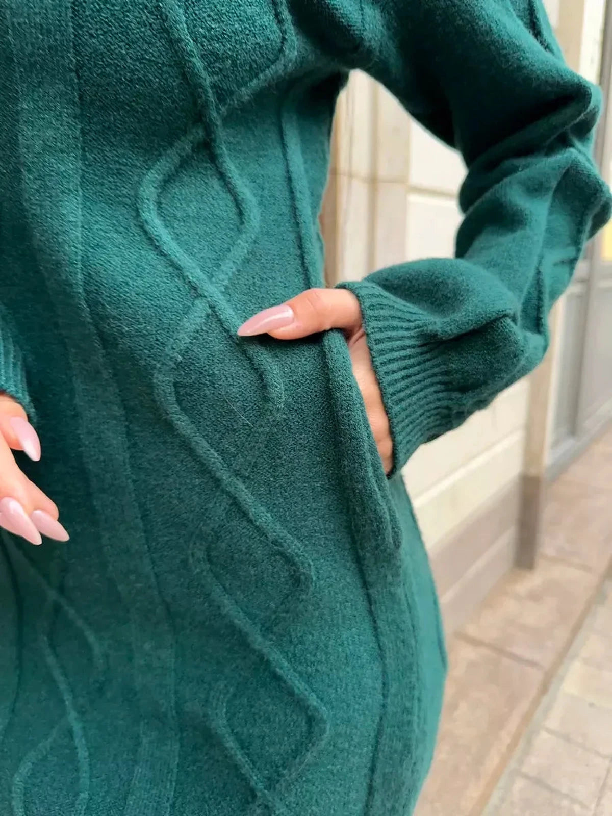 Close-up view of Selene Midi Dress by Lauven, showcasing textured knit fabric and elegant pockets in emerald green.