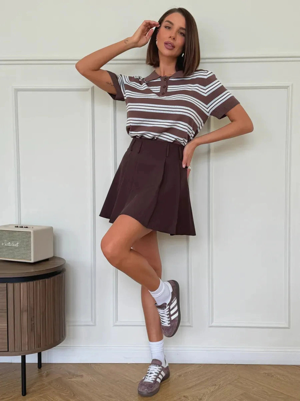 Verona Mini Skirt by Lauven, chocolate brown pleated A-line skirt styled with a striped top and trendy sneakers.