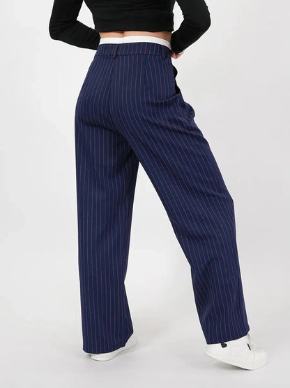 Model wearing Aster Pants by Lauven, showcasing refined high-waist wide-leg silhouette in navy pinstripes.