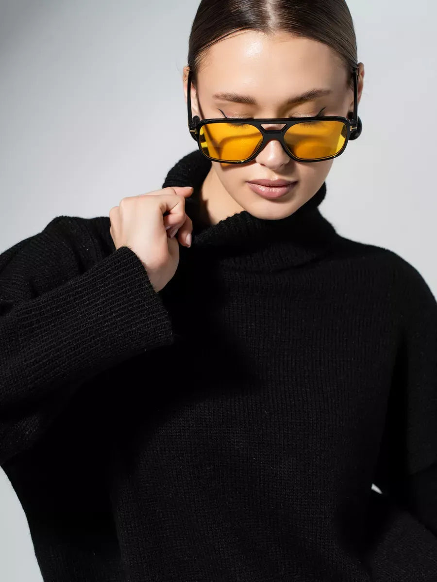 Onyx Sweater by Lauven, oversized black knitwear with relaxed silhouette and model wearing yellow sunglasses.