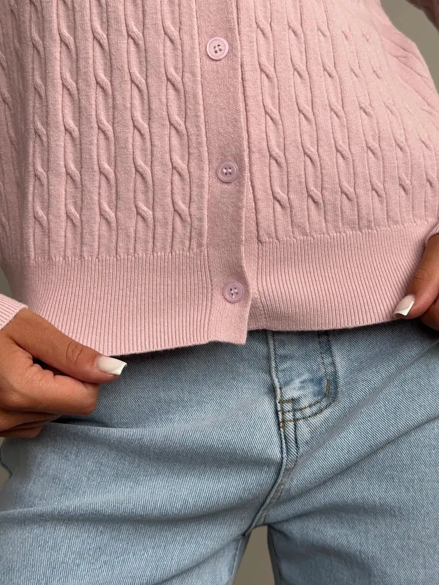 Close-up of a woman wearing a lightweight Rosewood Cardigan in pink cable knit detail by Lauven.