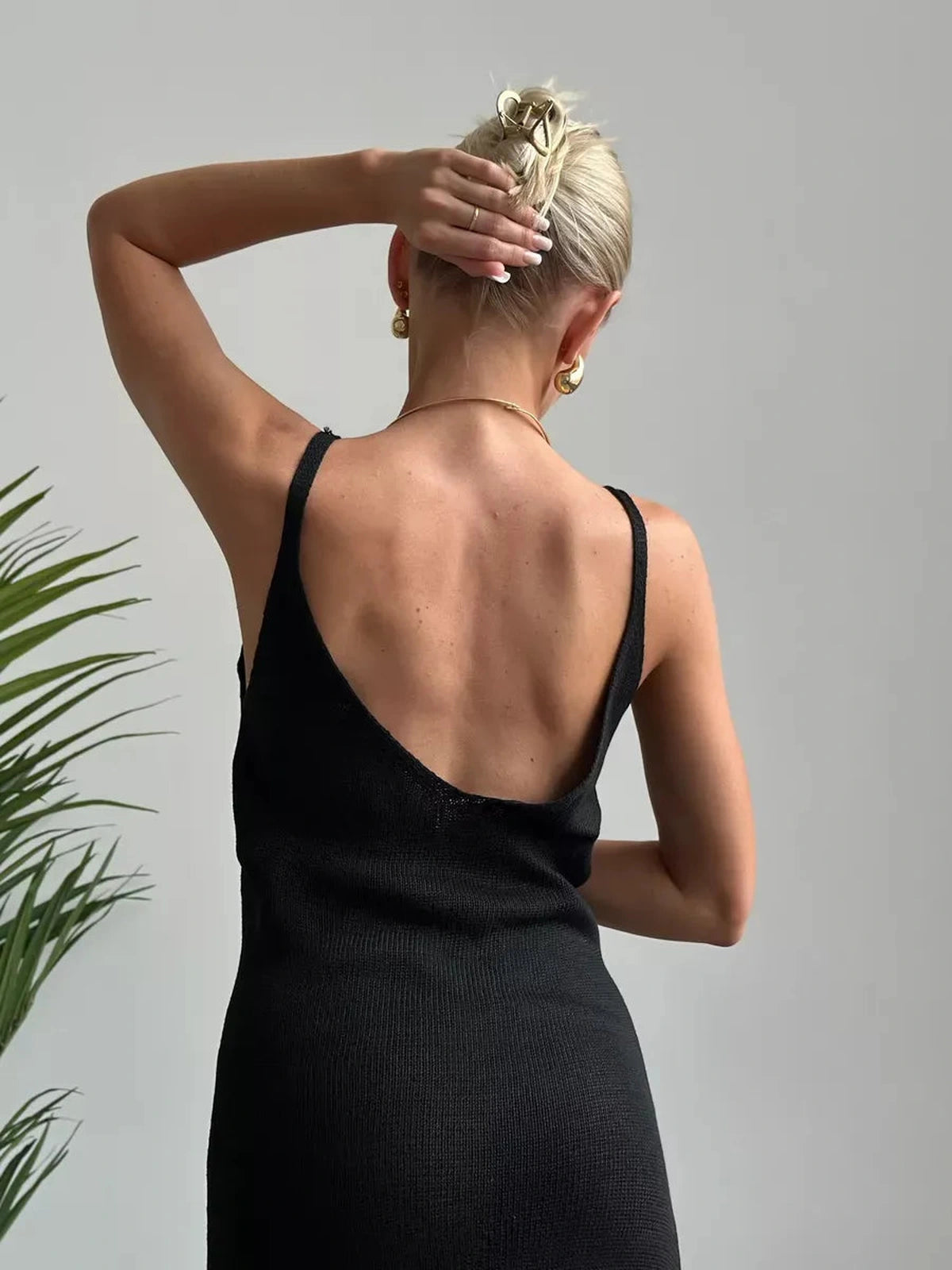 Back view of a model wearing the Vespera Maxi Dress by Lauven, featuring a deep neckline and sleek design.