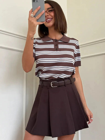 Model wearing a Verona Mini Skirt with a stylish striped polo top from Lauven, showcasing a chic chocolate brown look.