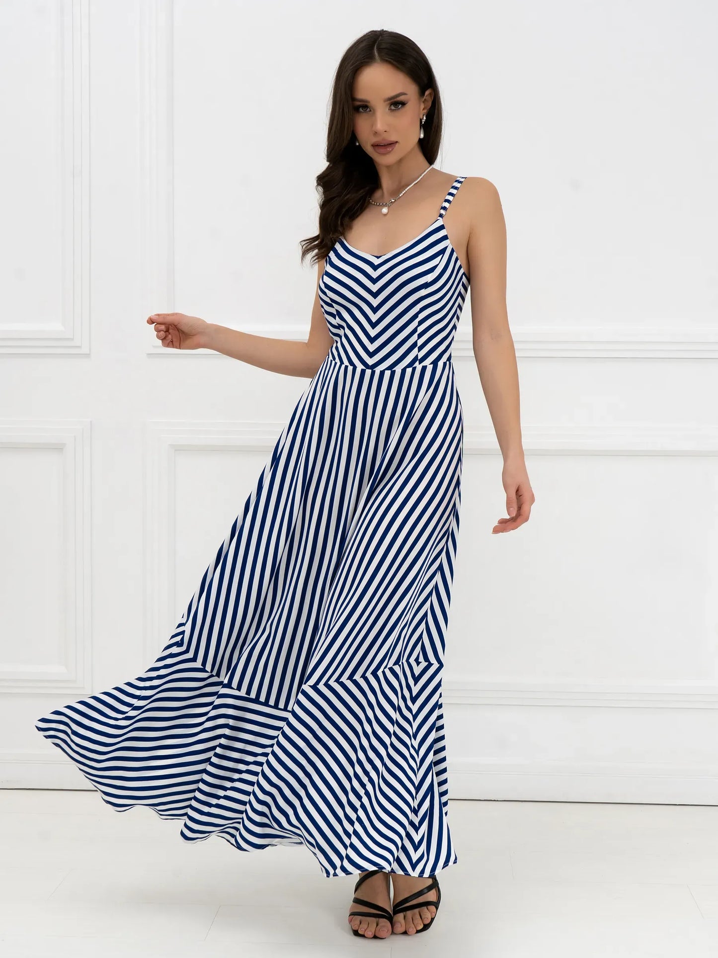 Model wearing the Marina Stripe Maxi Dress featuring bold stripes and flowing silhouette, perfect for summer outings.