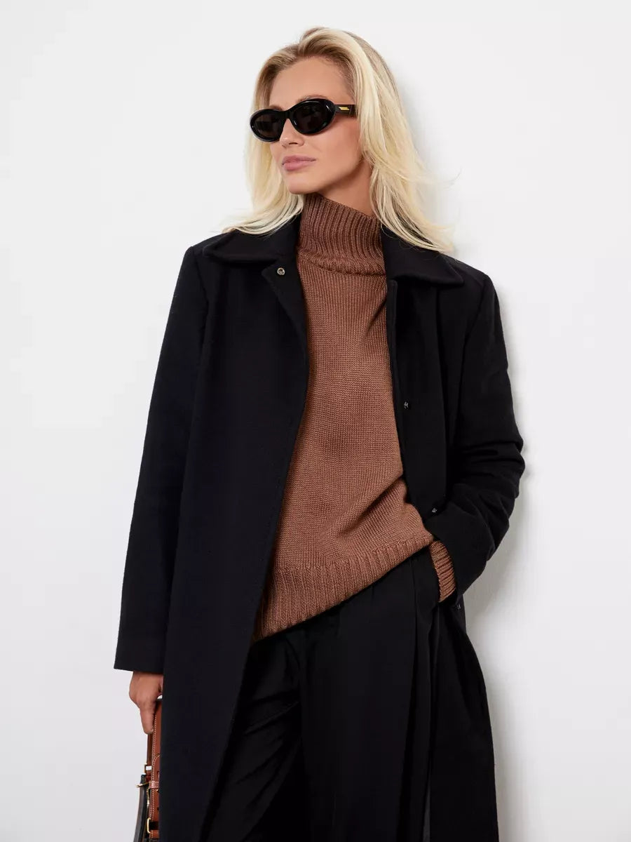Model wearing Maple Sweater in cocoa brown with black coat and sunglasses, showcasing cozy style by Lauven.