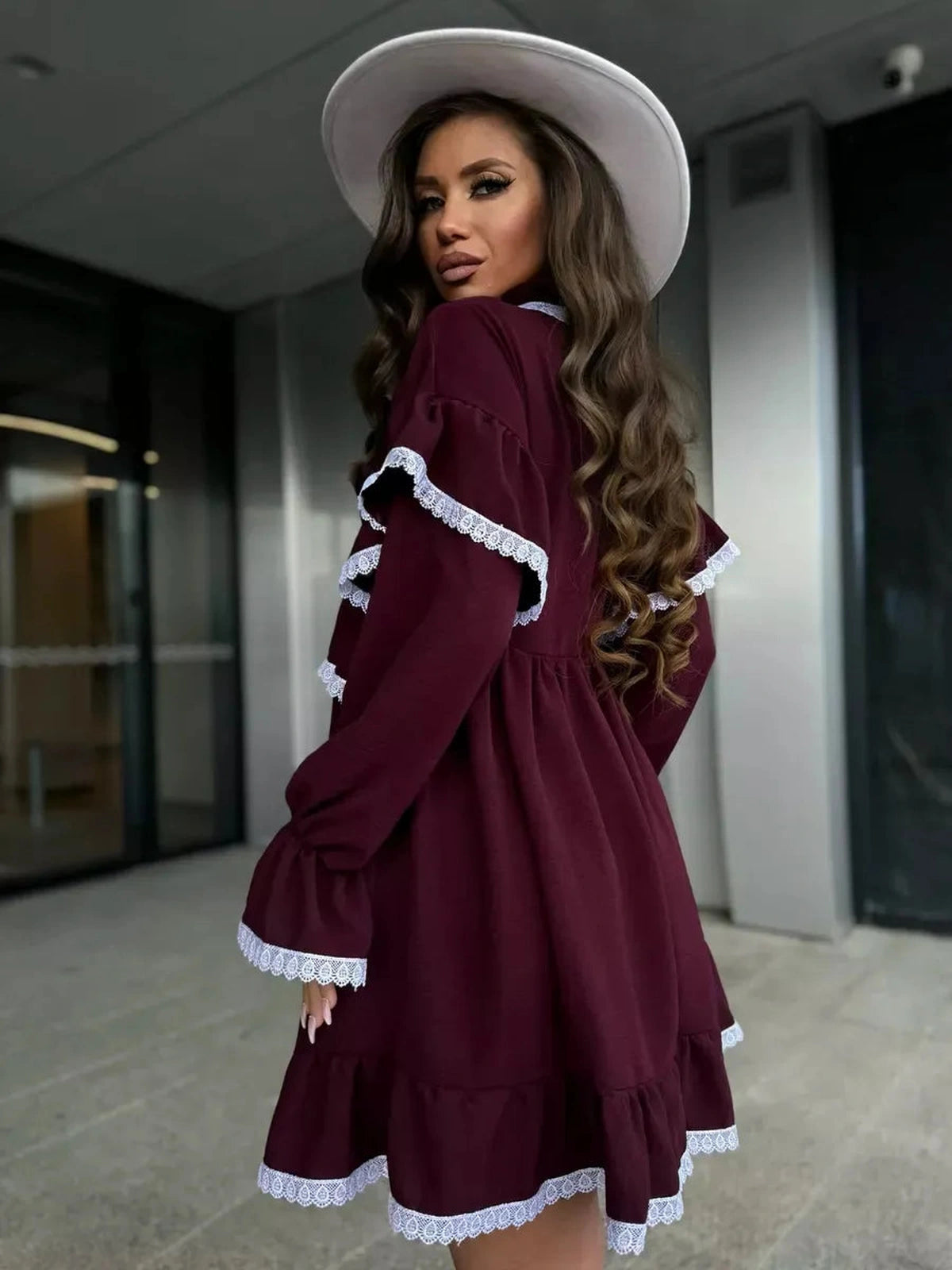 Model wearing the Marina Mini Dress by Lauven, showcasing delicate lace and ruffle details in burgundy.