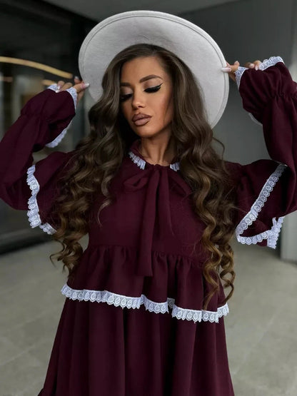 Elegant woman wearing Marina Mini Dress by Lauven, featuring ruffles and lace details in burgundy shade.