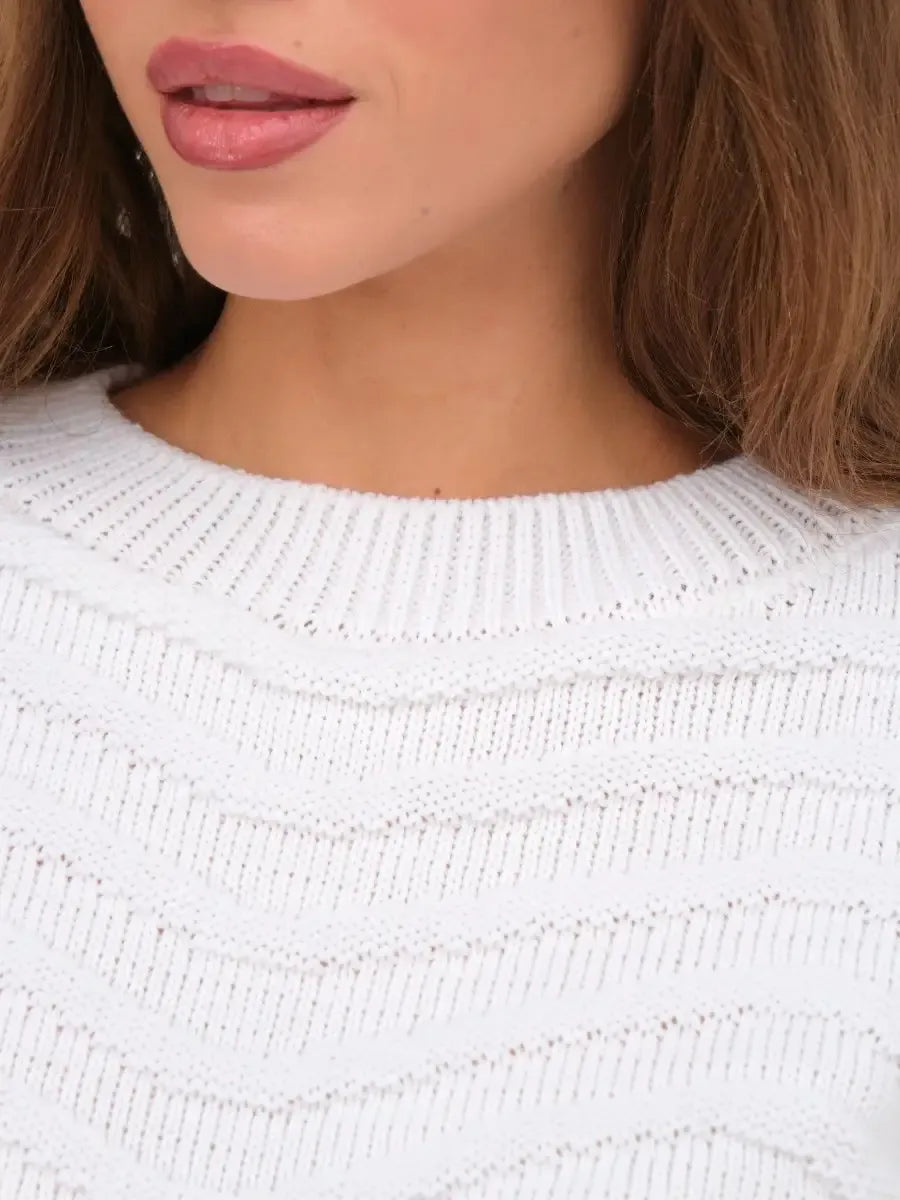 Close-up of a model wearing the Lyra Sweater by Lauven, showcasing its white cropped knit and relaxed silhouette.