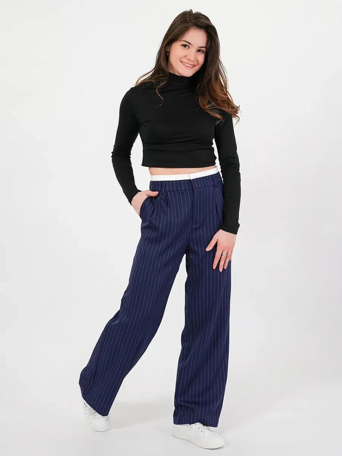 Aster Pants by Lauven featuring a model in high-waist wide-leg navy pinstripe trousers.
