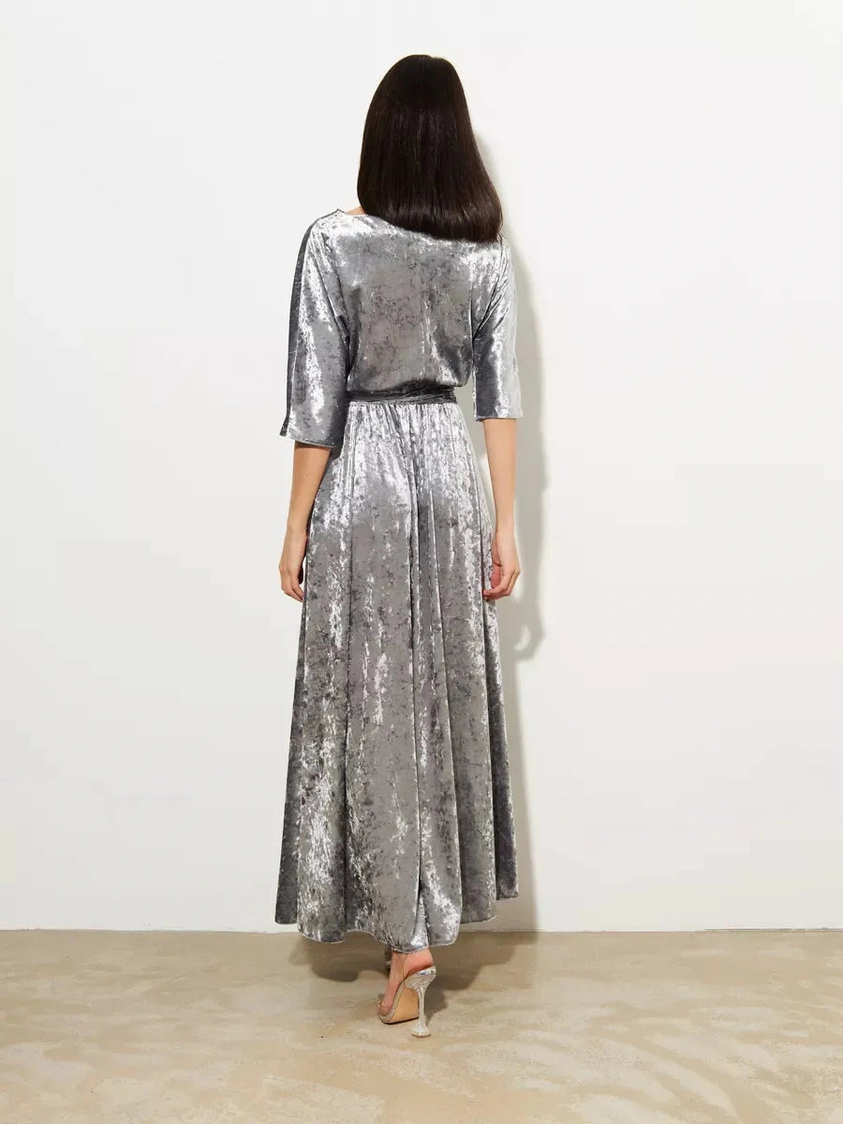 Back view of the Selene Maxi Dress by Lauven, showcasing shimmering silver velvet and elegant flowing design.