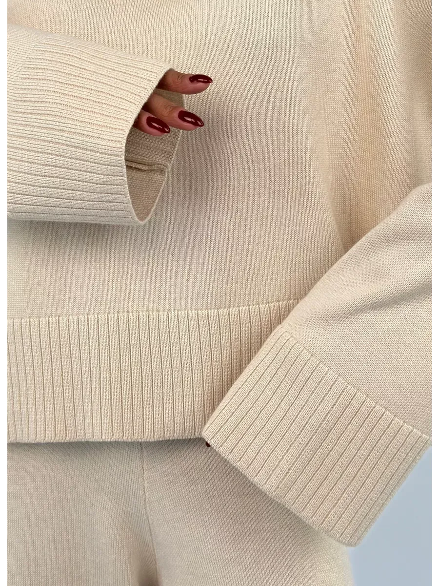 Close-up of the Eterna Sweater from Lauven, showcasing the light beige oversized knit texture and ribbed details.