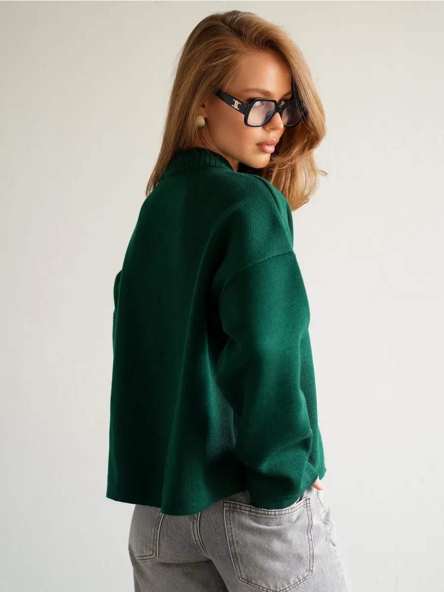 Woman wearing Verdant Cardigan by Lauven in rich emerald green, showcasing the cozy knitwear from the back.