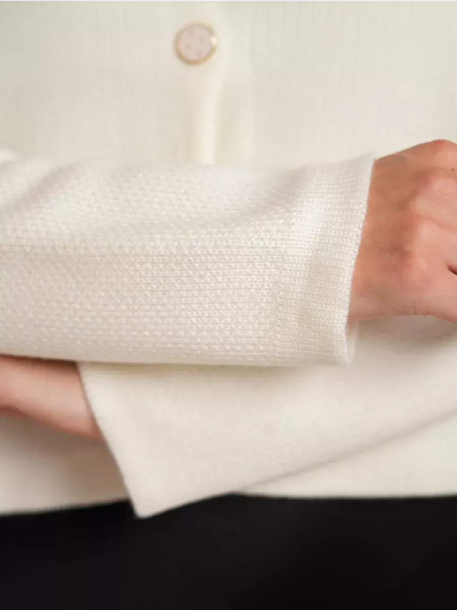 Ivory Cardigan by Lauven featuring a close-up of the creamy white knit and decorative button detail.