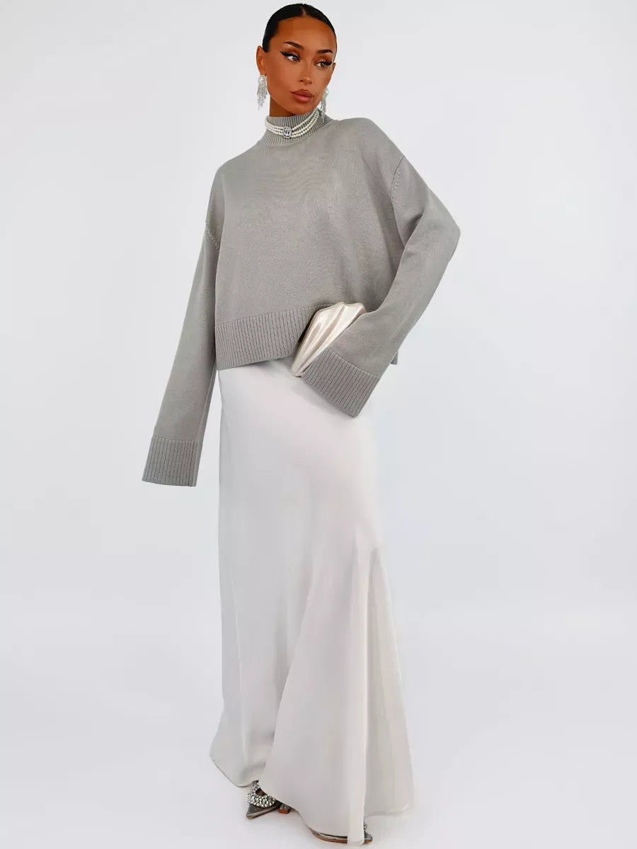 Arden Sweater by Lauven in gray, oversized cotton blend knit, styled with a sleek white skirt for chic look.