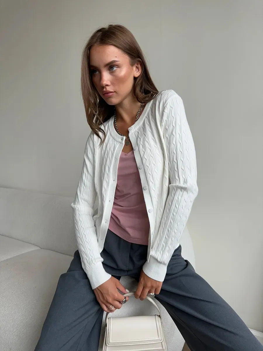 Model wearing an Ivory Cardigan by Lauven, featuring a lightweight cable knit pattern, styled with a pink top.