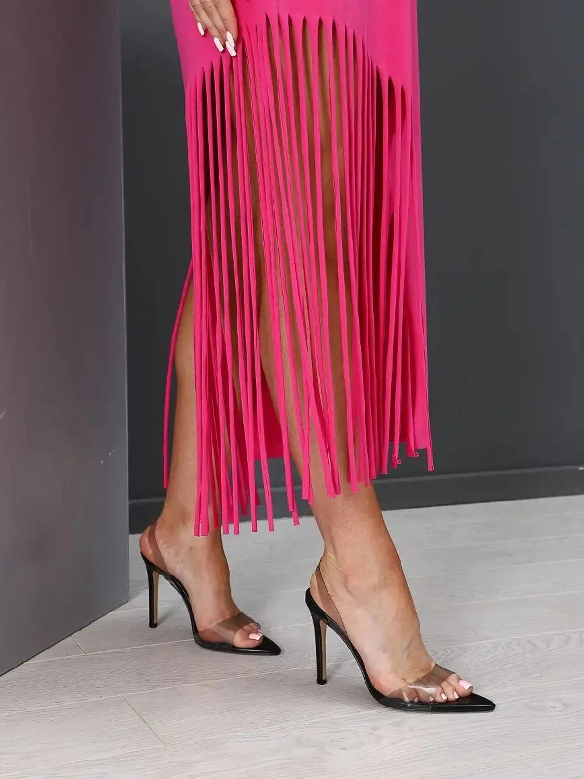 Capri Midi Dress detail featuring trendy fringe hem in fuchsia, styled with chic black heels by Lauven.