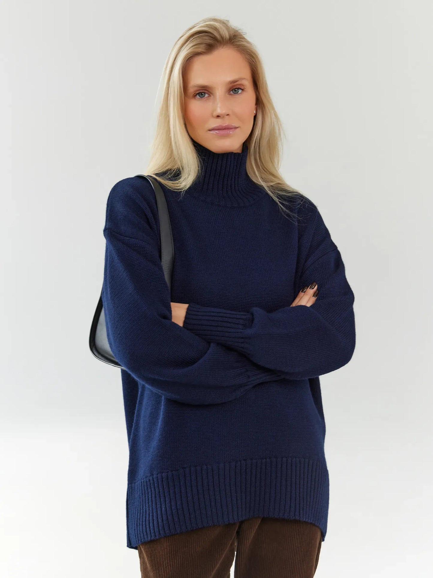 Celeste Sweater by Lauven: Oversized wool knit turtleneck in dark navy worn by a woman.