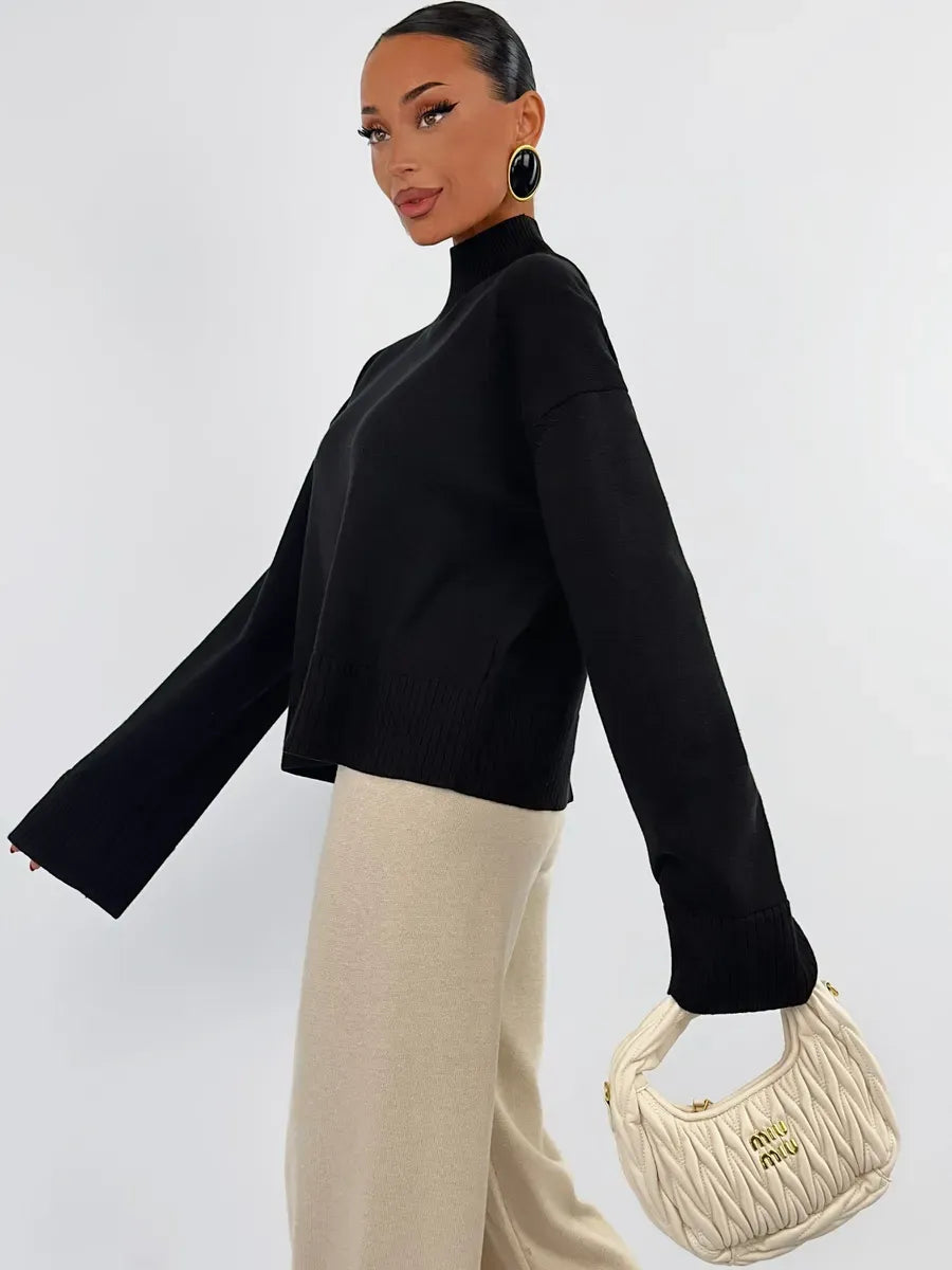 Noir Sweater by Lauven in oversized black knit, paired with neutral trousers and handbag, showcasing versatile style.