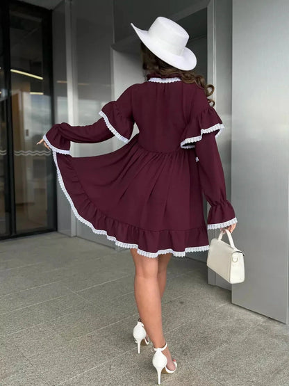 Model showcasing the Marina Mini Dress by Lauven, featuring lace trim and flared sleeves in burgundy.