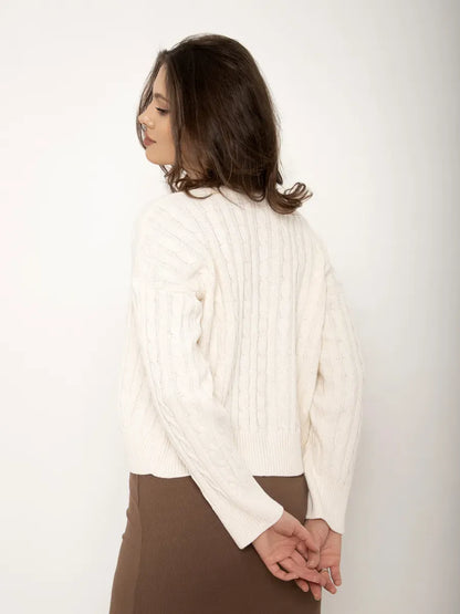 Back view of a woman wearing the Isola Cardigan by Lauven, featuring a cropped cream knit design.