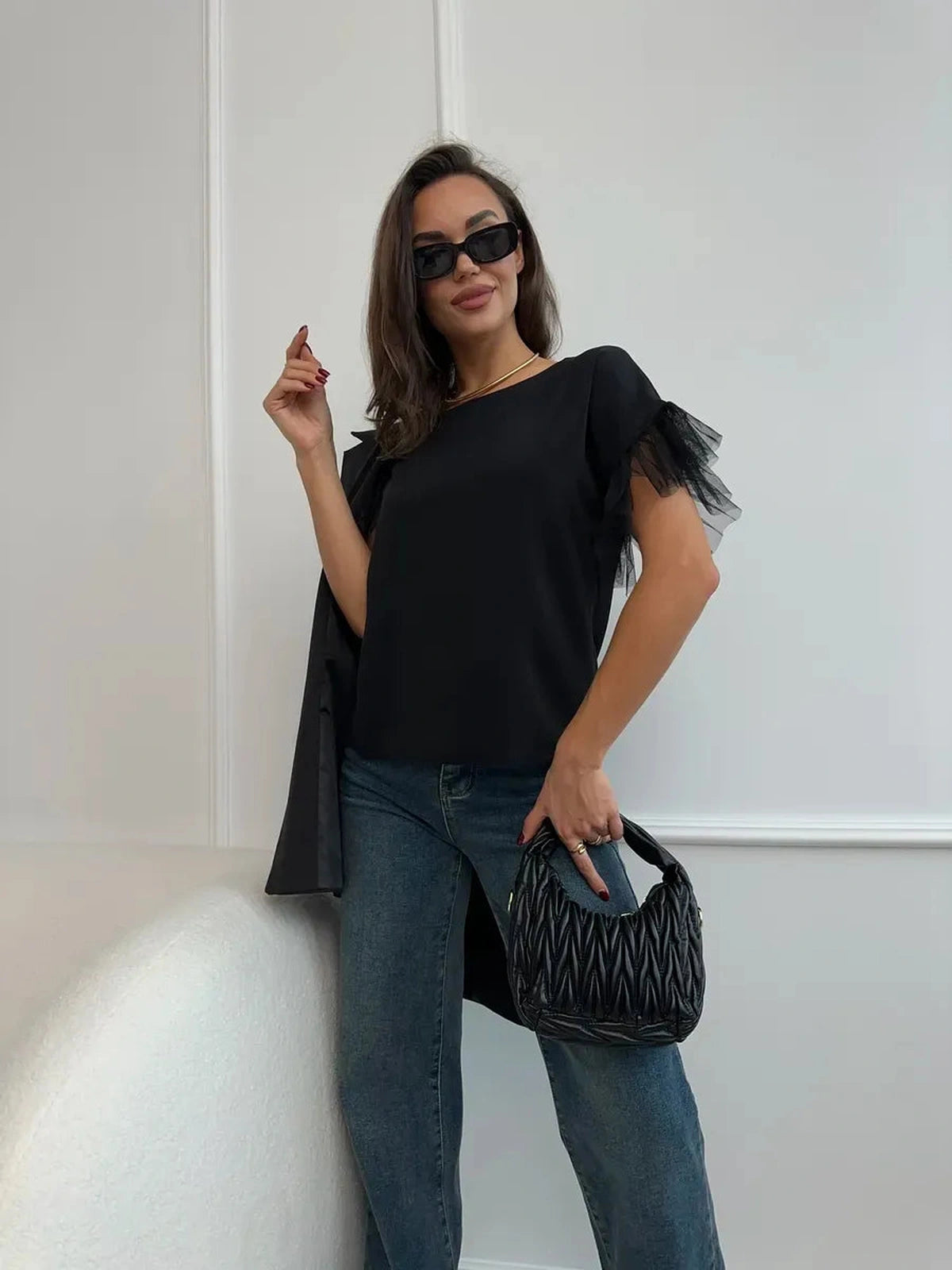Noiré Blouse by Lauven - Elegant black blouse with tulle ruffle detail, styled with jeans and handbag.