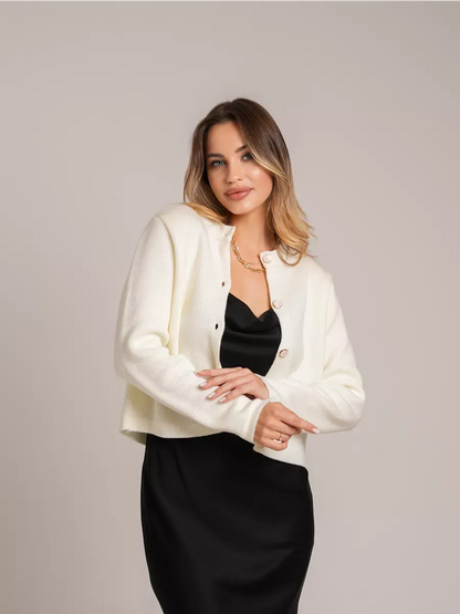 Ivory Cardigan by Lauven, creamy white short loose fit knit with decorative buttons worn over a black dress.