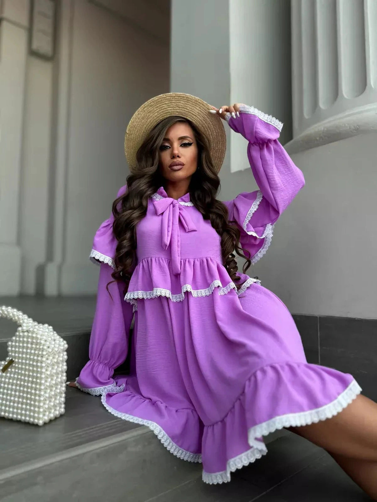 Stylish model wearing the Violetta Mini Dress by Lauven, featuring lace details and ruffles in lilac.