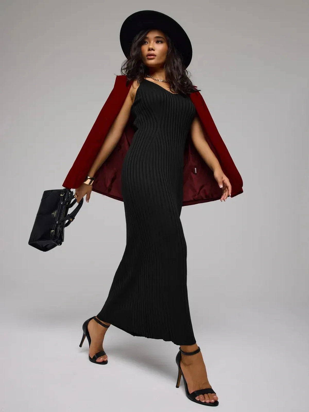 Model wearing the Noir Maxi Dress by Lauven, showcasing a sleek black ribbed knit design and stylish accessories.