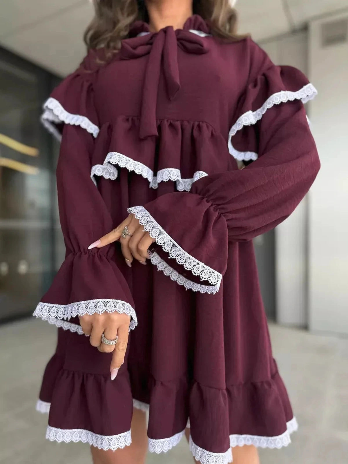 Marina Mini Dress in burgundy with lace and ruffle details by Lauven, showcasing oversized silhouette and flared sleeves.
