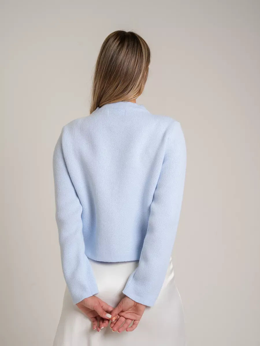 Back view of a woman wearing the light blue Celeste Cardigan by Lauven, showcasing its elegant design and soft texture.