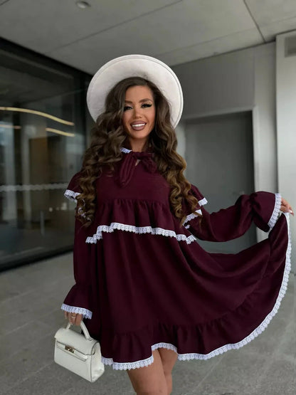 Model wearing Lauven Marina Mini Dress featuring delicate lace and ruffle details in burgundy.