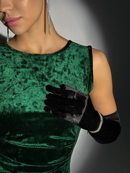 Close-up of a model in a green velvet dress featuring the Emeralda Maxi Dress by Lauven with elegant black gloves.