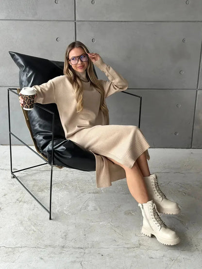 Woman in beige Seren Midi Dress by Lauven, sitting in a chair, holding coffee, showcasing minimalist knit sophistication.