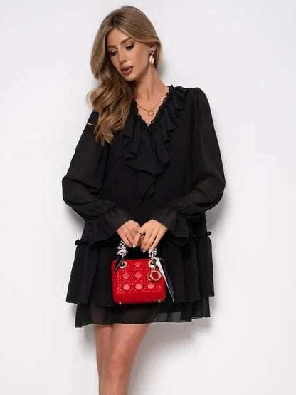 Noirelle Mini Dress by Lauven showcased in black chiffon with ruffled layers, paired with a red handbag.