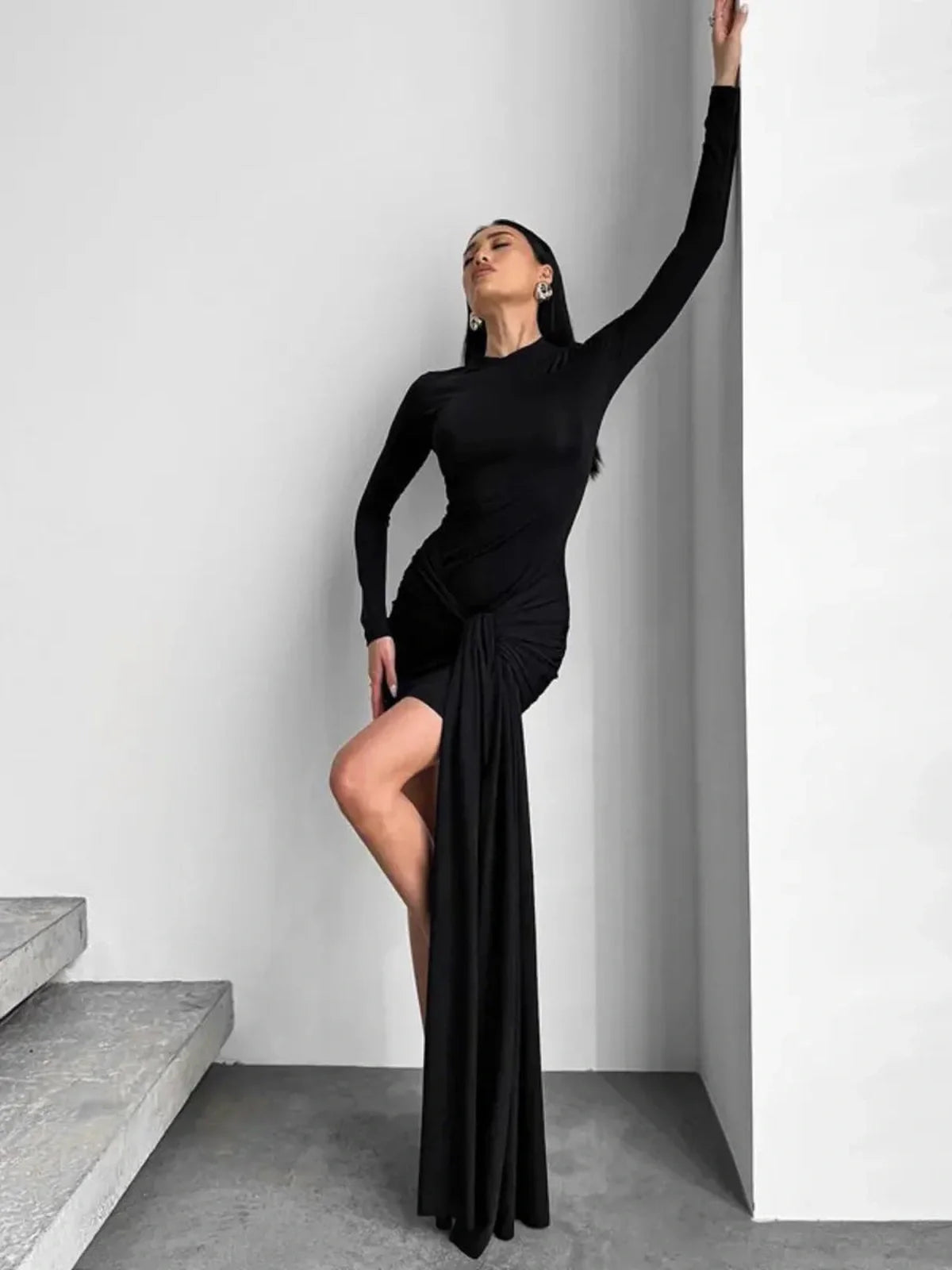 Model showcasing the Obsidian Veil black mini dress with structured waist and dramatic draping.