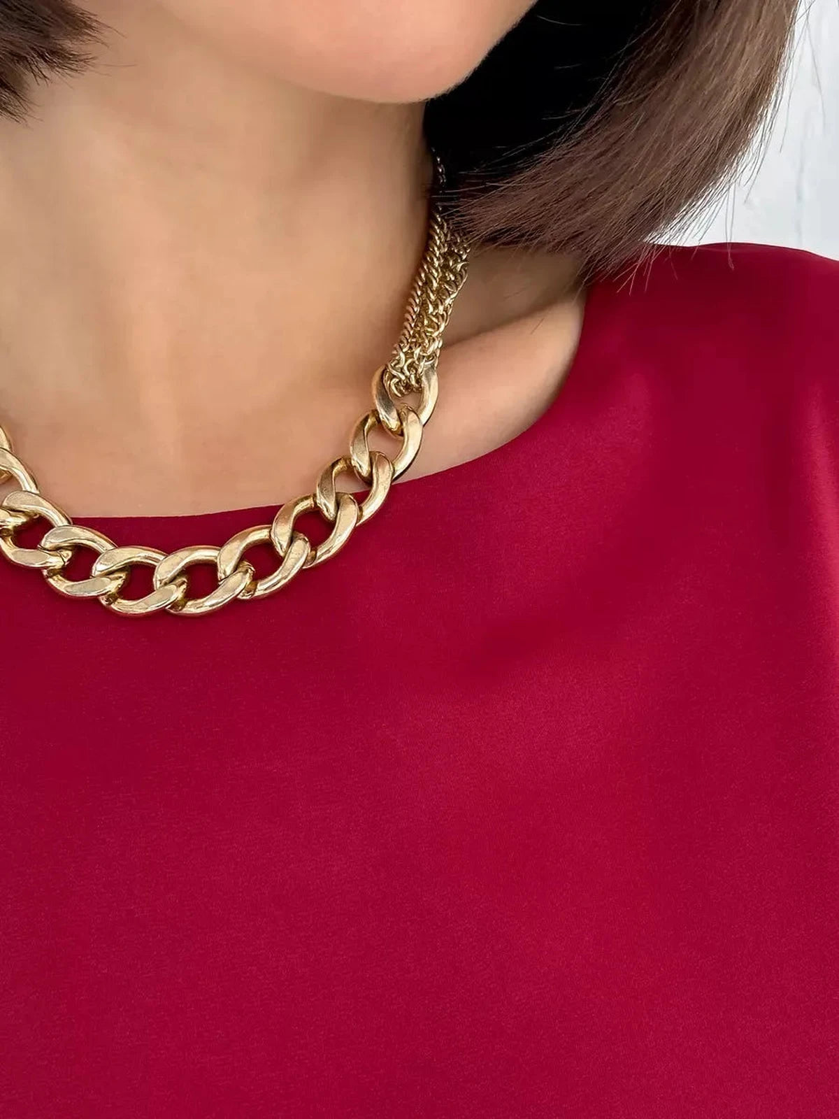 Velora Blouse by Lauven featuring a burgundy fabric and elegant gold chain necklace.