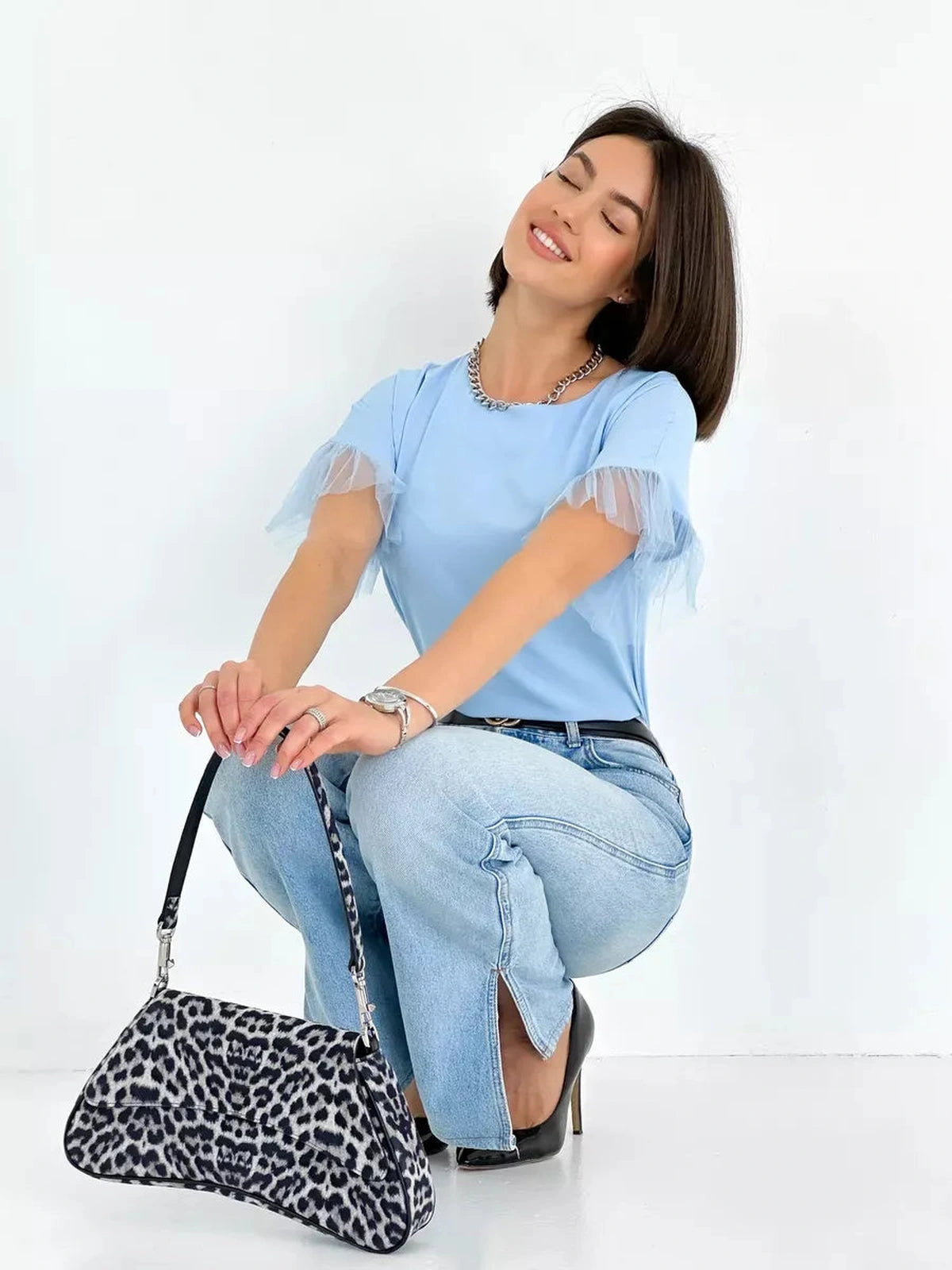 Celeste Blouse by Lauven featuring light blue silky fabric and tulle details, styled with jeans and a leopard print bag.
