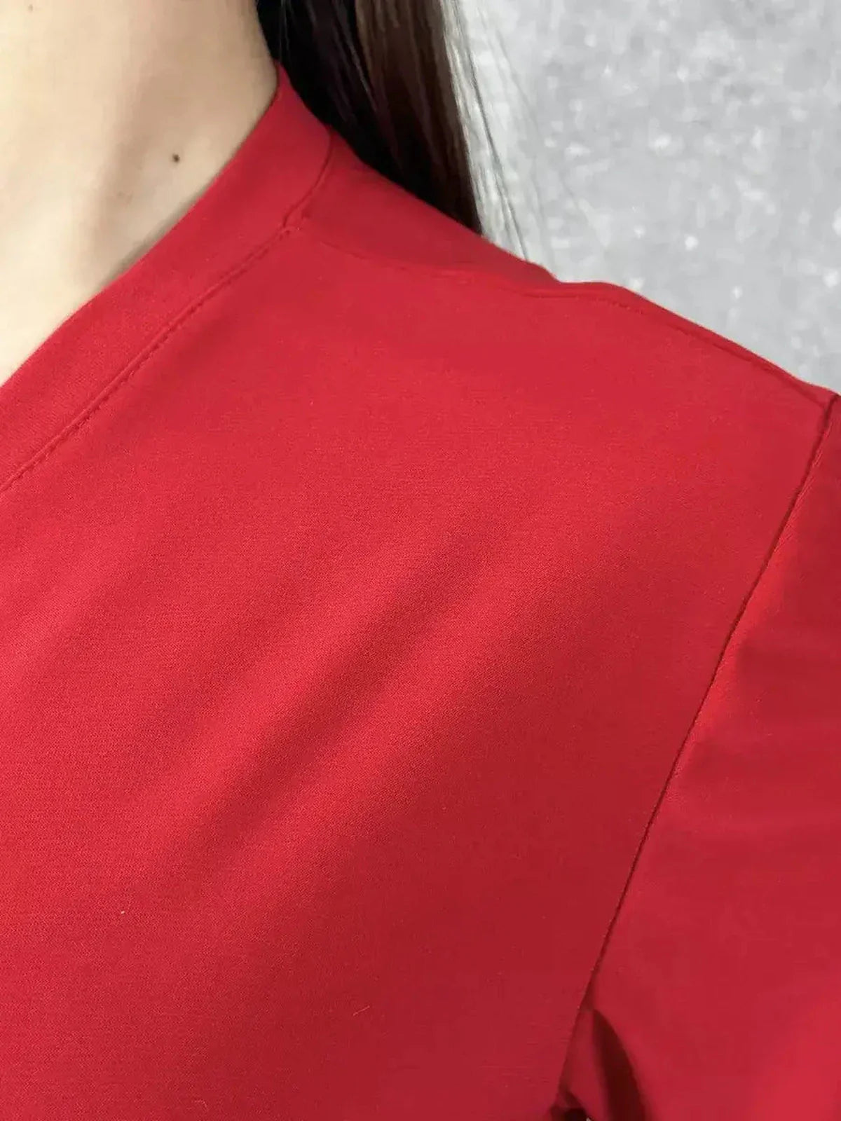 Close-up of the elegant red fabric of the Maxi Dress Scarlet Drape, highlighting its soft texture and refined design.